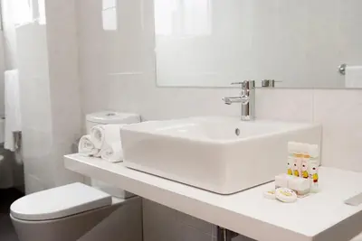 a white bathroom with a sink and a toilet at Hotel Universal in Santiago de Compostela