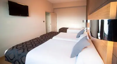 a hotel room with two beds and a flat screen tv at Hotel Universal in Santiago de Compostela
