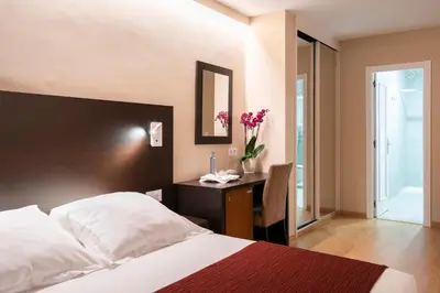 a bedroom with a bed and a desk with a mirror at Hotel Santiago Apóstol in Santiago de Compostela