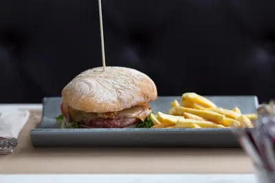a sandwich and french fries on a plate at Hotel Santiago Apóstol in Santiago de Compostela