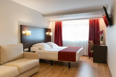a hotel room with a bed and a chair at Hotel Santiago Apóstol in Santiago de Compostela