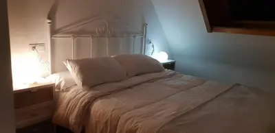 a white bed with white pillows and a lamp at Piedad Fernandez Fernandez Gestion de Inmuebles - II in Burela de Cabo