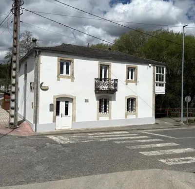 a white building with a balcony on a street at Casa De Don Lino in Lugo