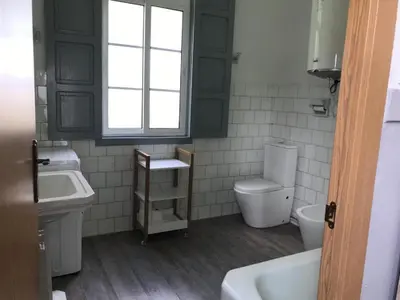 a bathroom with a sink and a toilet and a window at Casa De Don Lino in Lugo