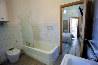 a bathroom with a tub and a sink and a bed at Casa De Don Lino in Lugo
