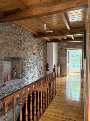a staircase with a stone wall and wooden ceiling at Casa De Don Lino in Lugo