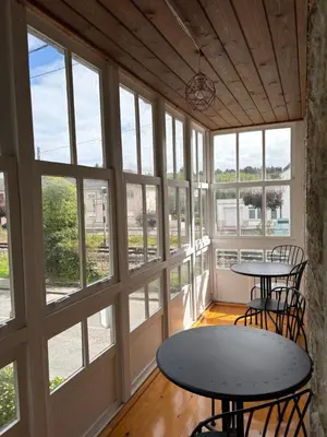 two tables and chairs in a room with windows at Casa De Don Lino in Lugo