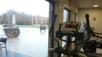 a gym with a machine in a room at Hotel Spa Attica21 Vilalba in Villalba