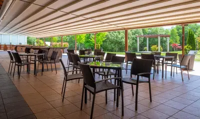 a restaurant with tables and chairs on a patio at Hotel Spa Attica21 Vilalba in Villalba