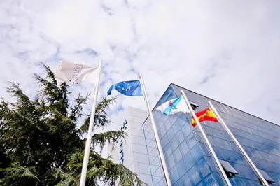 three flags flying in front of a building at Hotel Auditorio Santiago & Spa in Lugo