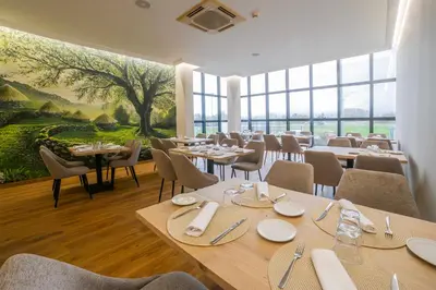 a restaurant with tables and chairs and a large window at Hotel Auditorio Santiago & Spa in Lugo