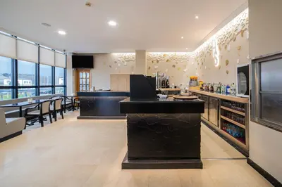 a large kitchen with a bar and a dining area at Hotel Auditorio Santiago & Spa in Lugo