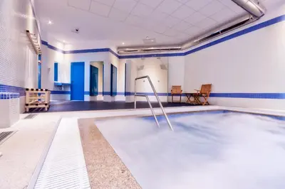 a swimming pool in a room with blue and white walls at Hotel Auditorio Santiago & Spa in Lugo