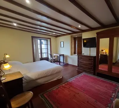 a bedroom with a bed and a television and a table at Casa Grande de Fuentemayor in Silleda