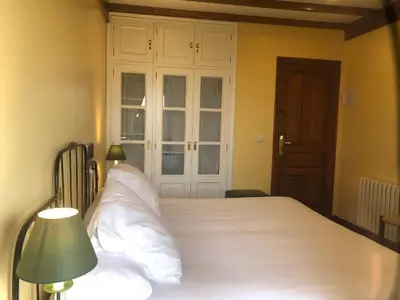 a bedroom with a large white bed with a green lamp at Casa Grande de Fuentemayor in Silleda
