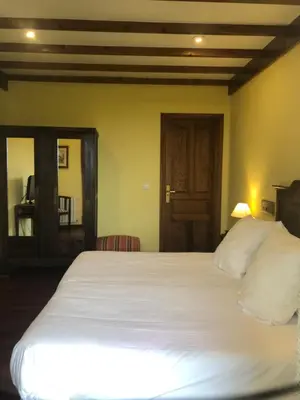 a bedroom with a large white bed and a mirror at Casa Grande de Fuentemayor in Silleda