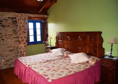 a bedroom with a bed with a dog laying on it at Casa Assumpta in Arzúa