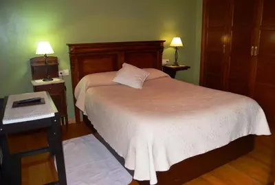 a bedroom with a bed and a table with a keyboard at Casa Assumpta in Arzúa