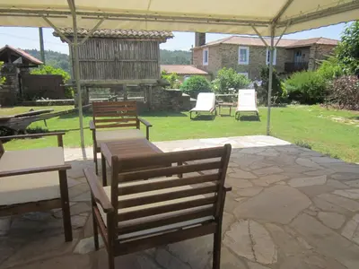 a patio with a table and chairs under a tent at Casa Assumpta in Arzúa