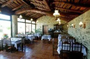 a dining room with tables and chairs in a building at Casa Assumpta in Arzúa
