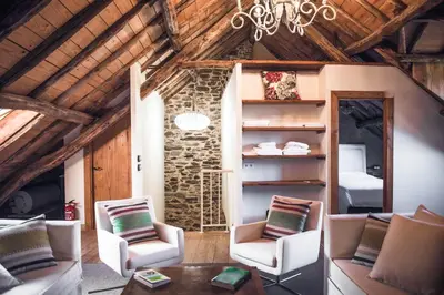 a living room with chairs and a table and a ceiling at Houmi As Bouzas in Castrelo de Miño