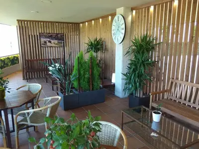 a restaurant with plants and a clock on the wall at Hotel Parking Miradoiro de Belvís in Santiago de Compostela
