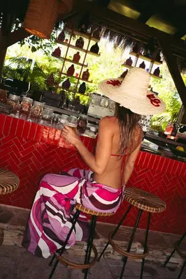 a woman in a hat sitting at a bar at Casa Beatnik Country House in Santiago de Compostela