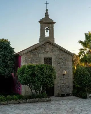an old stone church with a bell tower on top at Casa Beatnik Country House in Santiago de Compostela