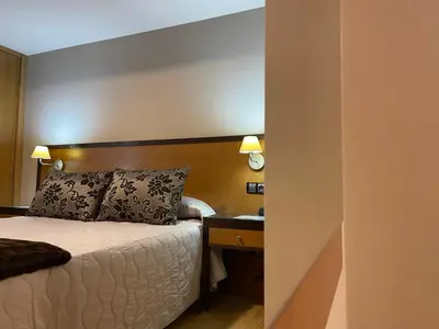 a hotel room with a bed and a desk and a bed sidx sidx sidx at Aparthotel Arenteiro in Carballino