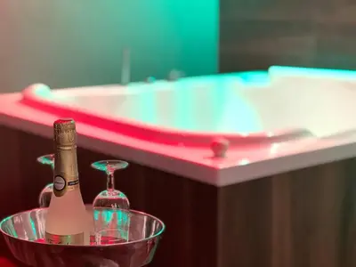 a bathroom with a tub and a champagne bottle in a bowl at Aparthotel Arenteiro in Carballino