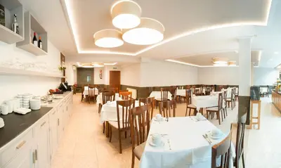 a dining room with white tables and chairs at Hotel San Lorenzo in Santiago de Compostela