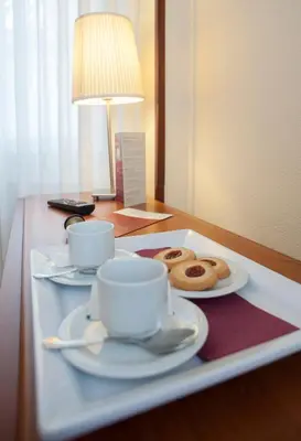 two donuts and two cups on a tray on a table at Hotel San Lorenzo in Santiago de Compostela