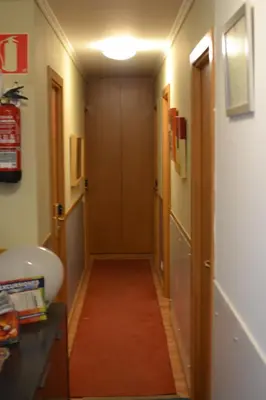 a hallway leading to a bathroom with a door at Pensión Da Estrela in Santiago de Compostela