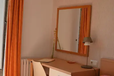 a room with a desk with a mirror and a lamp at Pensión Da Estrela in Santiago de Compostela