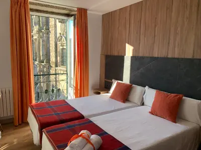 a bedroom with a bed and a large window at Pensión Da Estrela in Santiago de Compostela