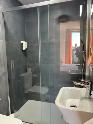 a bathroom with a shower and a toilet and a sink at Pensión Da Estrela in Santiago de Compostela