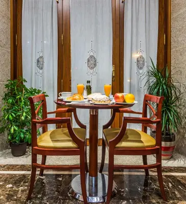 a dining room table with two chairs and oranges on it at Hotel Herradura in Santiago de Compostela