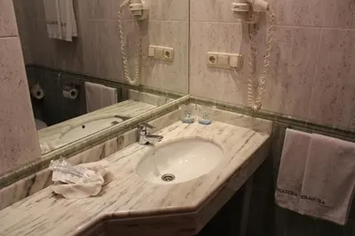 a bathroom with a sink and a mirror at Hotel Herradura in Santiago de Compostela