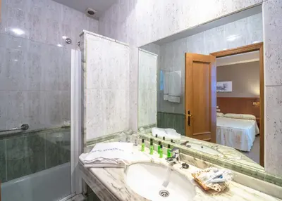 a bathroom with a sink and a mirror at Hotel Herradura in Santiago de Compostela