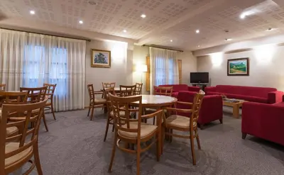 a waiting room with tables and chairs and a tv at Hotel Herradura in Santiago de Compostela