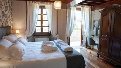 a bedroom with a bed with towels on it at SNÖ Pazo de Adrán in Milladoiro