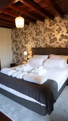 a bedroom with a large bed with white pillows at SNÖ Pazo de Adrán in Milladoiro