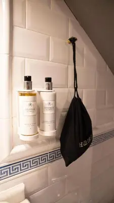 a shelf with two bottles and a black purse at SNÖ Pazo de Adrán in Milladoiro