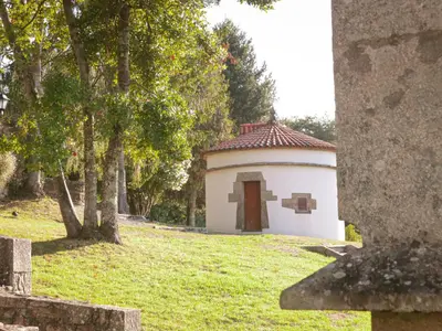 a small building with a cross on the grass at SNÖ Pazo de Adrán in Milladoiro