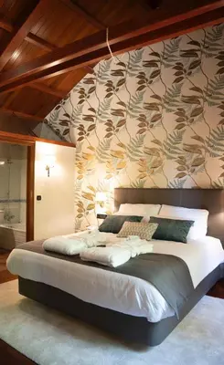 a bedroom with a large bed with a wall at SNÖ Pazo de Adrán in Milladoiro