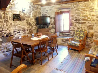 a dining room with a wooden table and chairs at Casa da Laxa in Beáriz