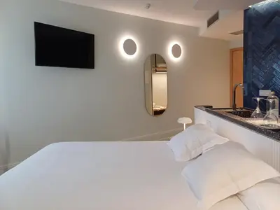a bedroom with a white bed with a tv on the wall at Ruta Jacobea in Lavacolla