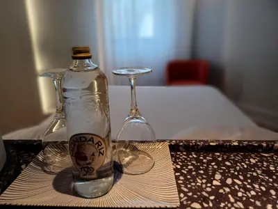 a bottle and two glasses sitting on a table at Ruta Jacobea in Lavacolla