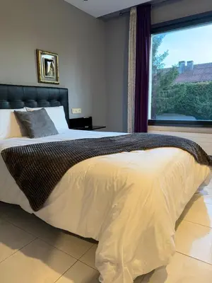 a bedroom with a large bed with a large window at Motel Montecarlo in Teo