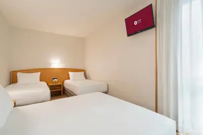 a hotel room with two beds and a window at Exe Area Central in Santiago de Compostela